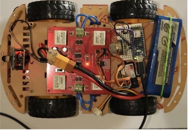 Top view of the built four-wheel rubble probe with motor driver, electronics, wiring, and battery
